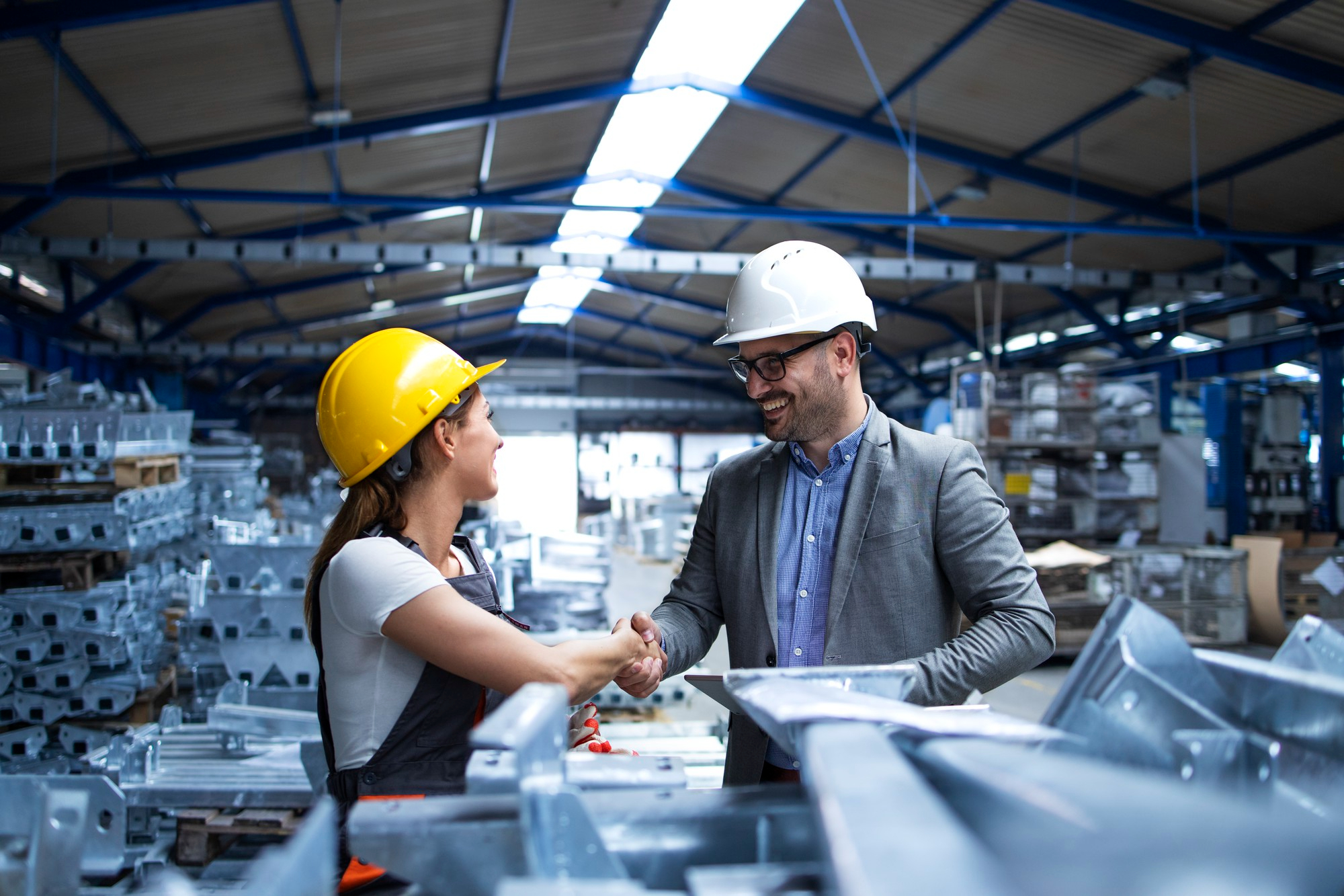 Manufacturing professionals shaking hands inside a facility
